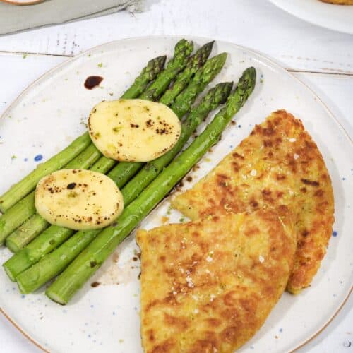 Two slices of potato rosti, 5 asparagus stalks and two pieces of mozzarella on a plate, with dressing | Hurry The Food Up