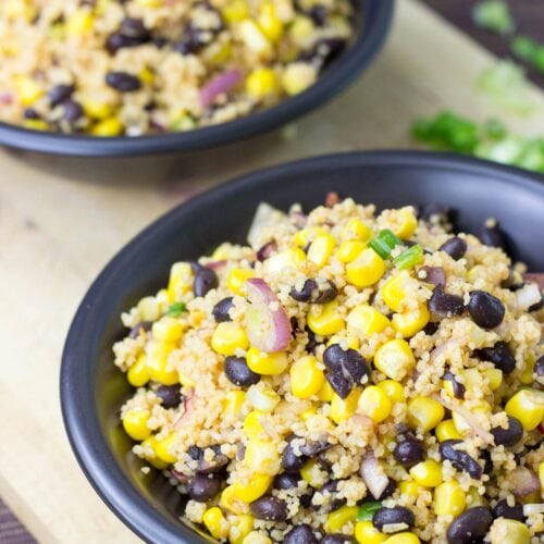 Two black bowls with high protein black bean salad with corn, that are on the wooden surface | HurryTheFoodUp