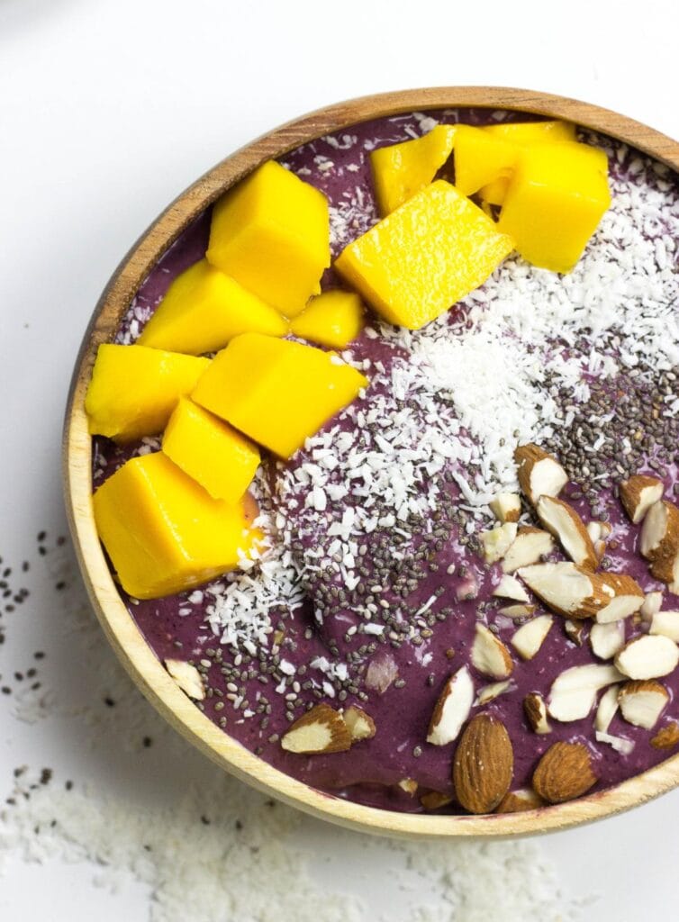 An acai bowl topped with coconut, chia, almonds, mango | Hurry The Food Up