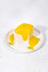 Japanese silken tofu dessert served on a plate with mango coulis and mint | Hurry The Food Up